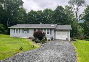 a small house with a driveway in a yard at Trout Town Inn in Roscoe