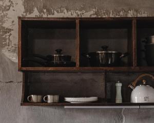 a wooden shelf with pots and pans on it at Hayag in General Luna