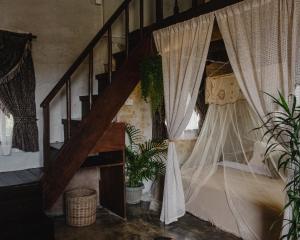a room with a staircase with curtains and plants at Hayag in General Luna