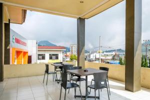 a patio with tables and chairs on a balcony at RedDoorz at Dieng 0KM in Diyeng