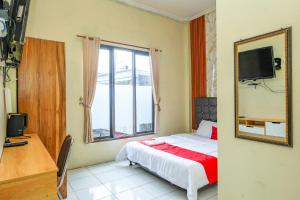 a bedroom with a bed and a window at RedDoorz at Dieng 0KM in Diyeng