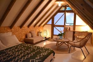 a bedroom with a bed and a table and chairs at Le Fare de la Baleine in Punaauia