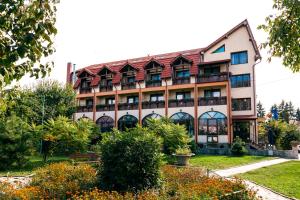 a building with a garden in front of it at Pensiunea Siva in Horezu