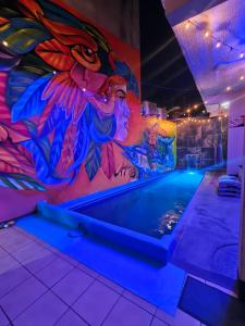 a pool with a colorful mural on the wall at Hotel Familiar El Dorado in Zihuatanejo