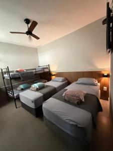 a room with four beds and a ceiling fan at Hotel Valle in Patrocínio