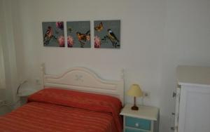 a bedroom with three pictures of cats on the wall at Apartamento Los Flamencos in El Cabo de Gata