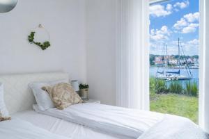 a bedroom with a bed with a view of the water at Port View - widok, 15m do jeziora, ogródek, parking podziemny, winda, Netflix i Prime in Iława