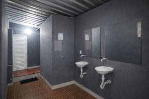 a bathroom with two sinks and a mirror at Itaúna Surf Camping in Saquarema +14 photos