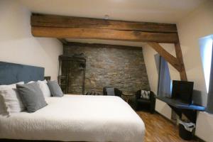 a bedroom with a white bed and a stone wall at Schmiede Hotel in Schoenberg