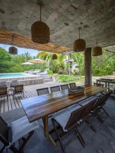 a dining room with a table and chairs and a pool at Vida Silvestre Tulum in Tulum