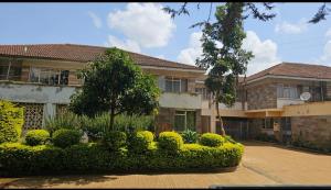 a building with a lot of bushes in front of it at Maurine Homestays in Eldoret