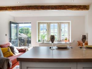 a kitchen with a table and a couch and windows at Kestrel Cottage in Holmfirth