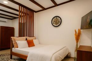 a bedroom with a bed with a clock on the wall at Appartements Des Roses in Le Lamentin