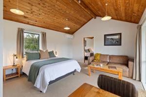a bedroom with a bed and a couch at Makoura Lodge in Apiti