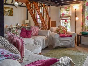 a living room with two couches and a staircase at The Old Thatch in Hailsham
