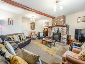 a living room with a couch and a fireplace at Berwyn Bank in Gilcrux