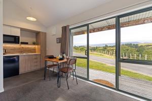 a kitchen with a table and chairs and large windows at Makoura Lodge in Apiti +26 photos
