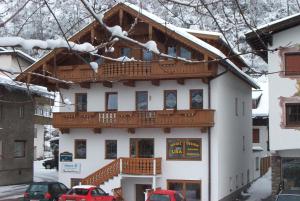 ein großes weißes Gebäude mit einem Holzbalkon in der Unterkunft Apartments Penz in Zellberg