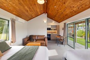 a bedroom with a bed and a living room at Makoura Lodge in Apiti