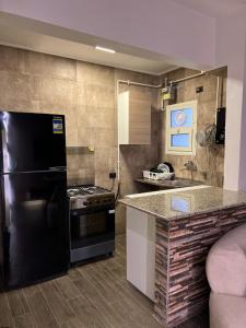 a kitchen with a black refrigerator and a stove at Tara Home 44 in Sheikh Zayed