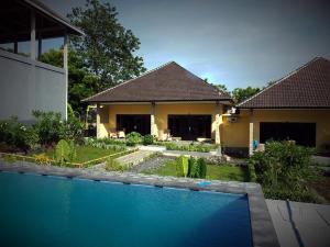 a house with a swimming pool in the yard at Scuba Tribe Bali dive-resort in Tulamben