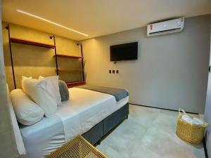 a small room with a bed and a tv at Marilyn Pousada Morro in Morro de São Paulo