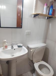 a white bathroom with a toilet and a sink at Las Tres Reinas A in Colorado River