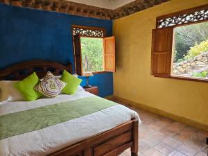 a bedroom with a bed and two windows at La Primavera, casas campestres para familias, paisajes, tranquilidad, cerca al pueblo in Villa de Leyva