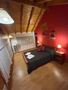 a bedroom with a black bed and red walls at Rincon de Ñires cabaña 4 in San Martín de los Andes