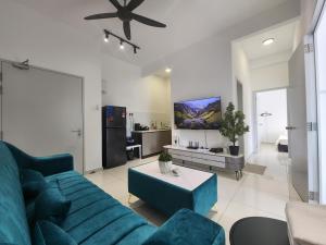 a living room with a blue couch and a tv at Horizon Rooftop Skypool Condotel - Ipoh in Ipoh
