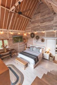 a bedroom with a large bed in a room with wooden walls at Garden Terrace Bali in Gobleg
