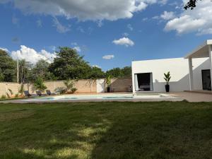 ein Hof mit einem weißen Gebäude und einem Zaun in der Unterkunft López in Capiatá