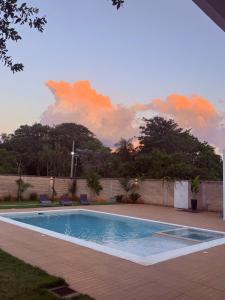 Ein Swimmingpool mit Sonnenuntergang im Hintergrund in der Unterkunft López in Capiatá + 3 Fotos