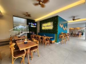 a dining room with wooden tables and chairs in a restaurant at Encanto da Praia LUXO Ap 2 qts Pe na Areia Camboinhas in Niterói