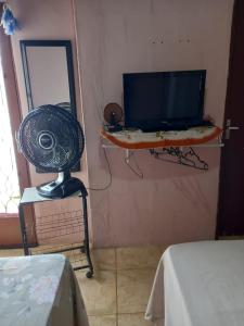 a room with a television and a table with a fan at kit net Rua Ildo Meneghetti, 160 in Alegrete +5 photos