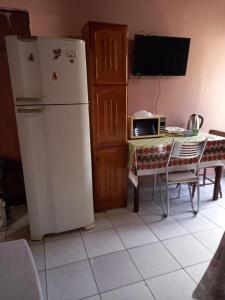 a kitchen with a refrigerator and a table with a microwave at kit net Rua Ildo Meneghetti, 160 in Alegrete
