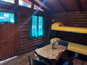 a dining room with a table and two bunk beds at Cabañas El Oasis del Peñón in Casa Grande