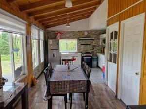 a dining room with a table and chairs in a kitchen at Cabaña Los Notros in Colonia Alerce