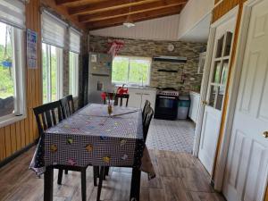 a dining room with a table and chairs in a kitchen at Cabaña Los Notros in Colonia Alerce +7 photos