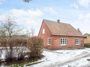 a red brick house with snow on the ground at Nature Escape Forest & Lake Access in Viborg