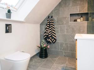 a bathroom with a toilet and a vase of flowers at Nature Escape Forest & Lake Access in Viborg +24 photos