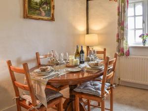 a dining room table with glasses and wine bottles at The Old Thatch in Hailsham