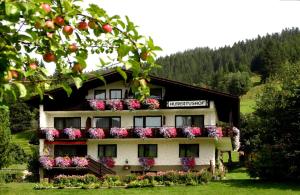 ein Gebäude mit Blumen auf der Seite in der Unterkunft Hubertushof in Jungholz