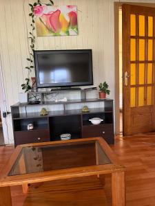 a living room with a tv and a coffee table at Espaciosa casa familiar en Queule in Nehuin +8 photos
