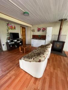 a large living room with a couch and a television at Espaciosa casa familiar en Queule in Nehuin