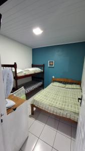 a bedroom with two bunk beds and a blue wall at Pousada Moschen in Passo de Torres