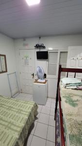 a room with two beds and a television in it at Pousada Moschen in Passo de Torres