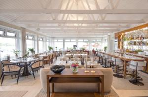 a dining room with tables and chairs and windows at Sandhamn Seglarhotell in Sandhamn
