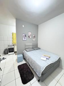 a bedroom with a bed in a white room at Apartamento Confortável Próx Unesp in Botucatu