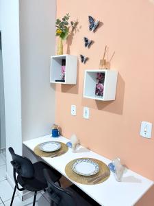 a table with two plates and butterflies on the wall at Apartamento Confortável Próx Unesp in Botucatu